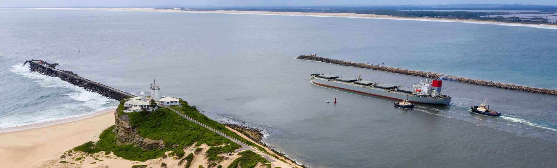 newcastle nsw port, ship accompanied by tug boats, stockton beach